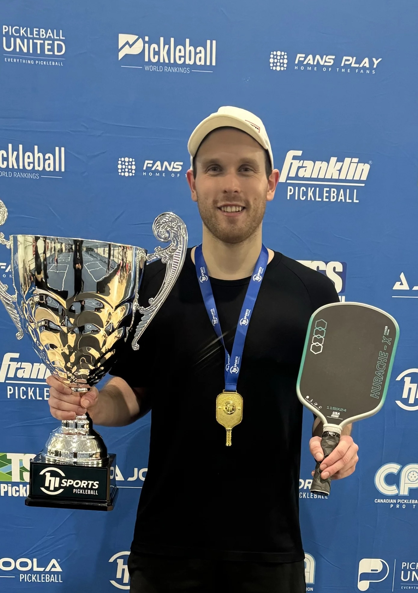 Joey Manchurek holding trophy and paddle at tournament